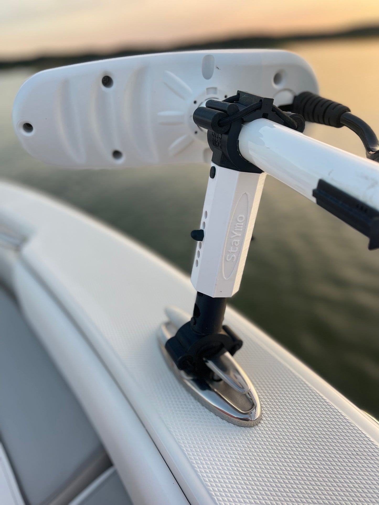 White Staymo trolling motor stabilizer attached to the boat pull up cleat with a sunset background